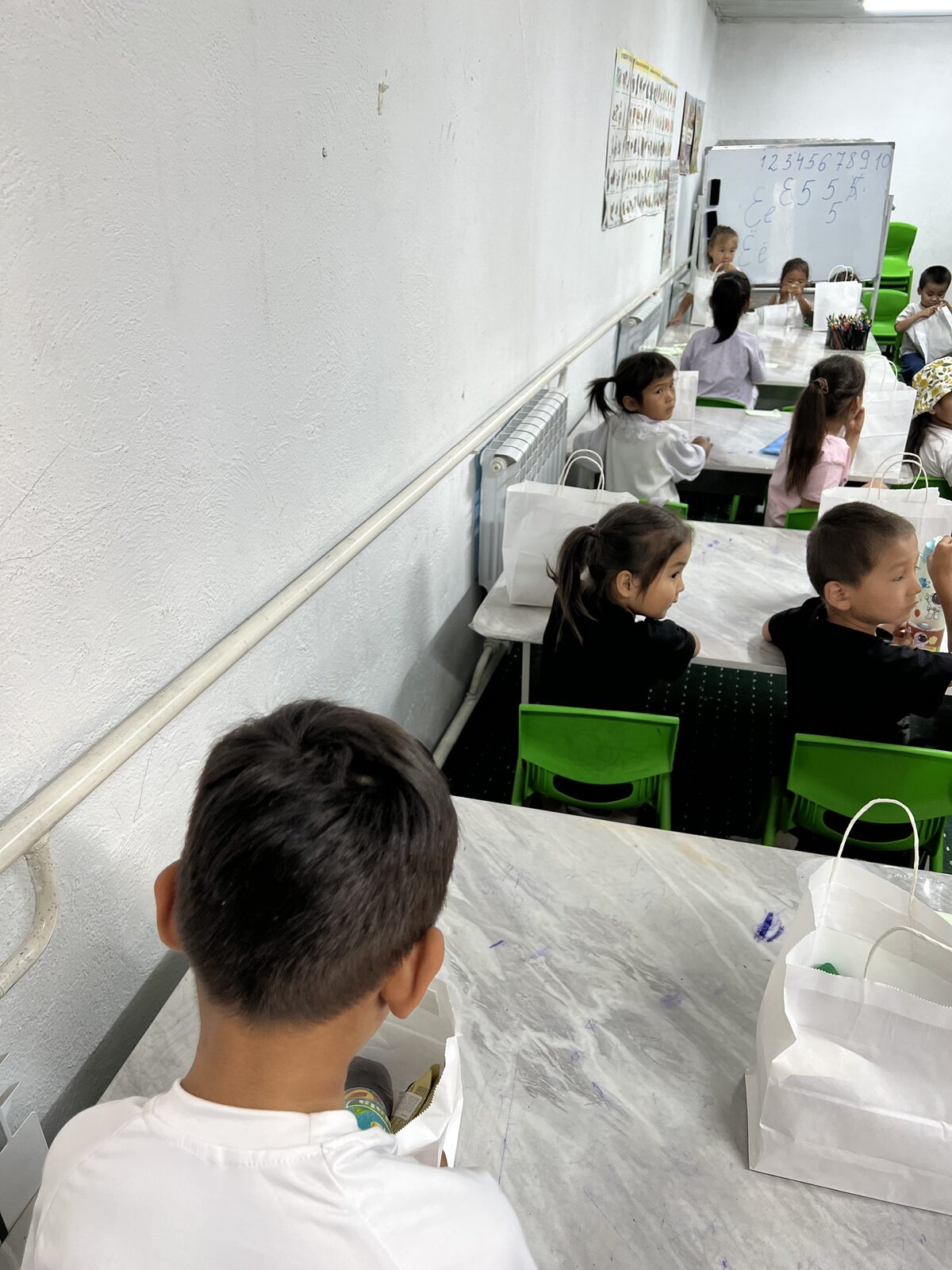 Young children practicing Cyrillic letters at desks