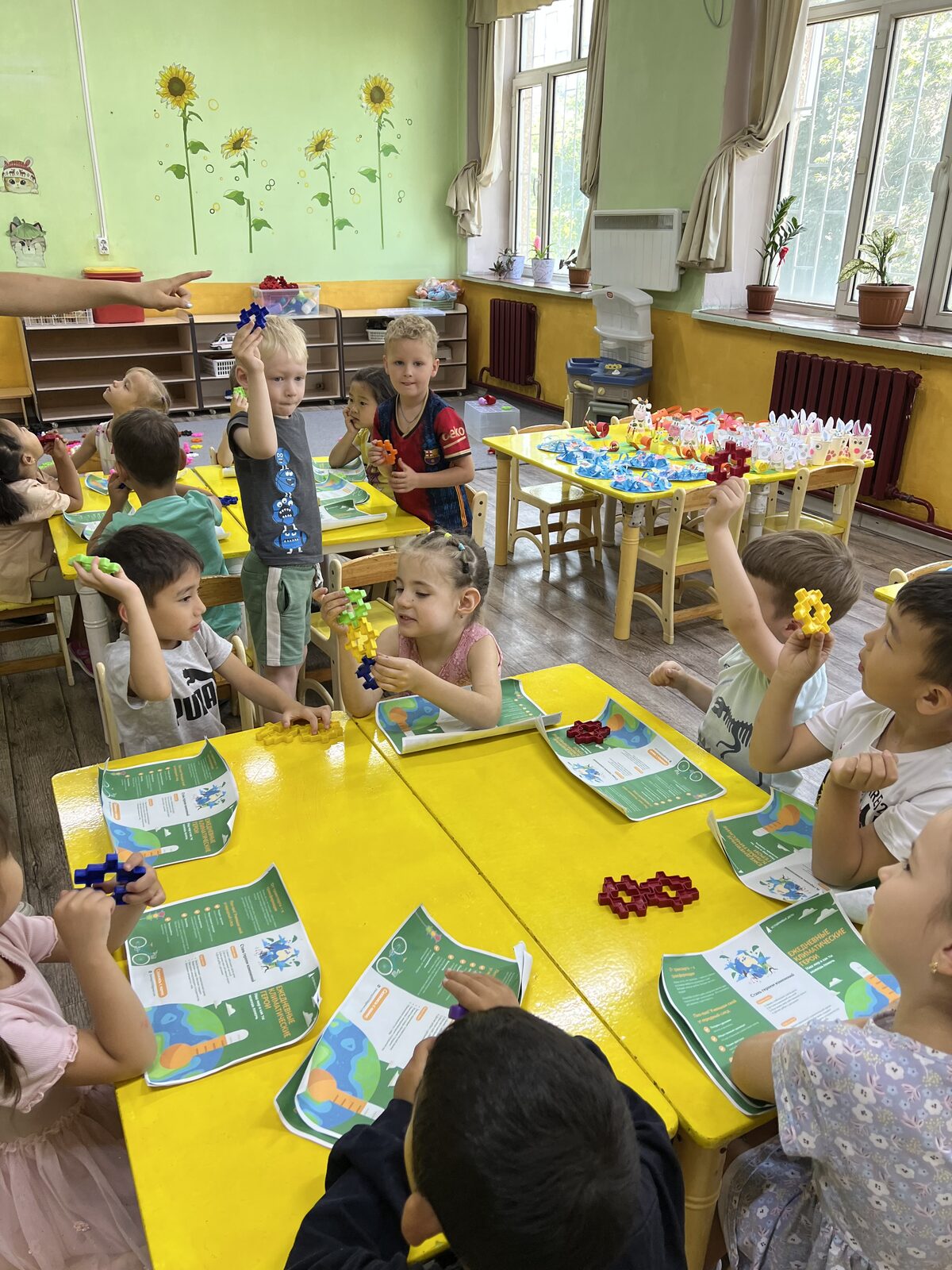 Kids at a table with a Daily Climate Heroes worksheet and building blocks