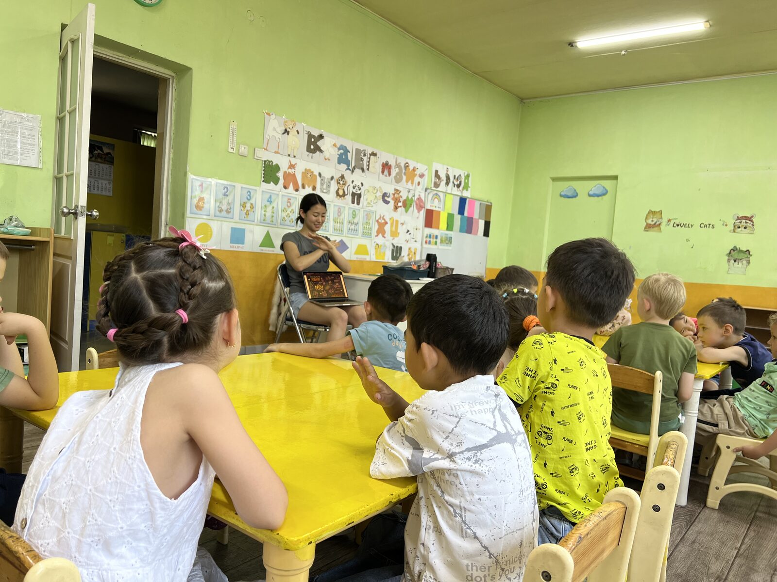 Teacher clapping with a group of young kindergarten children